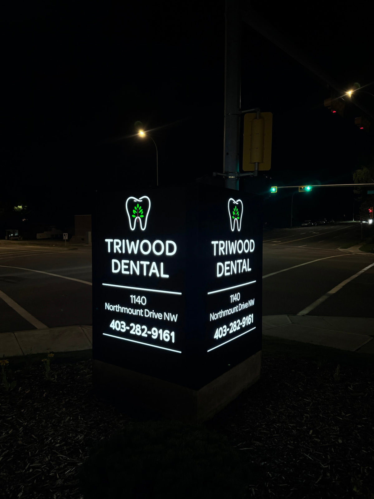 Triwood Dental illuminated pylon sign at night — Calgary pylon signs