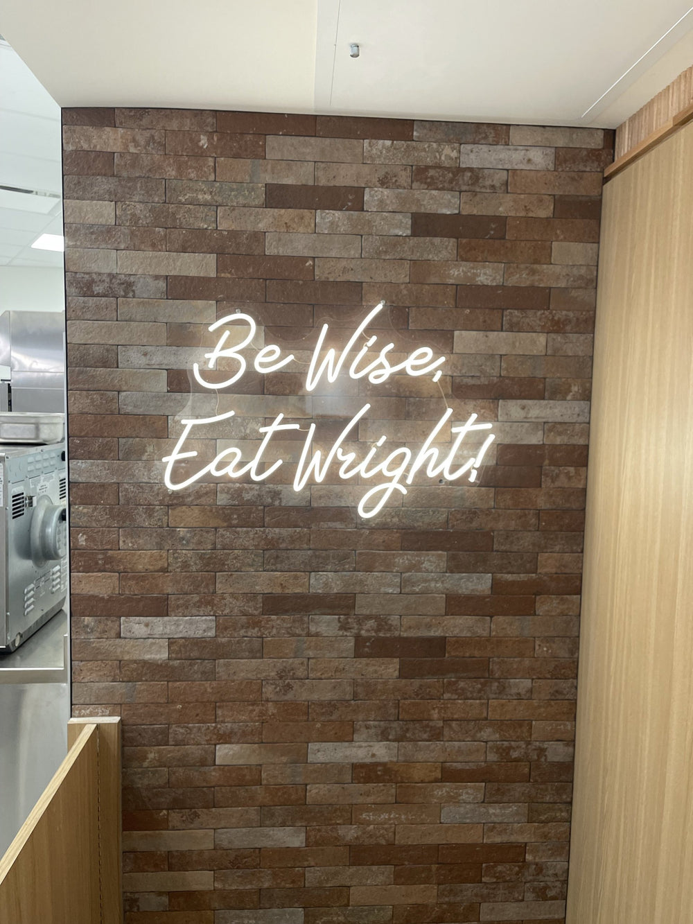 Be Wise Eat Wright white script LED neon on brick — NEON YYC Calgary