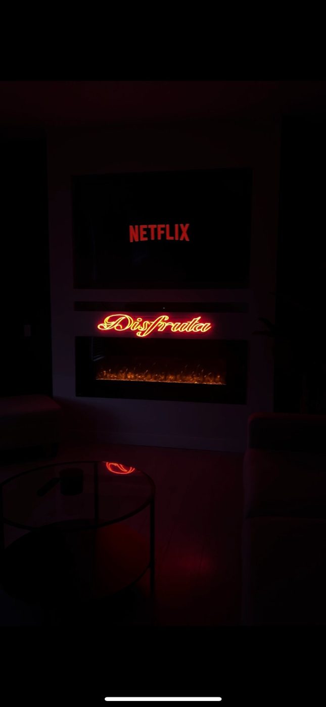 Disfruta custom gold script LED neon sign above fireplace — personal neon Calgary